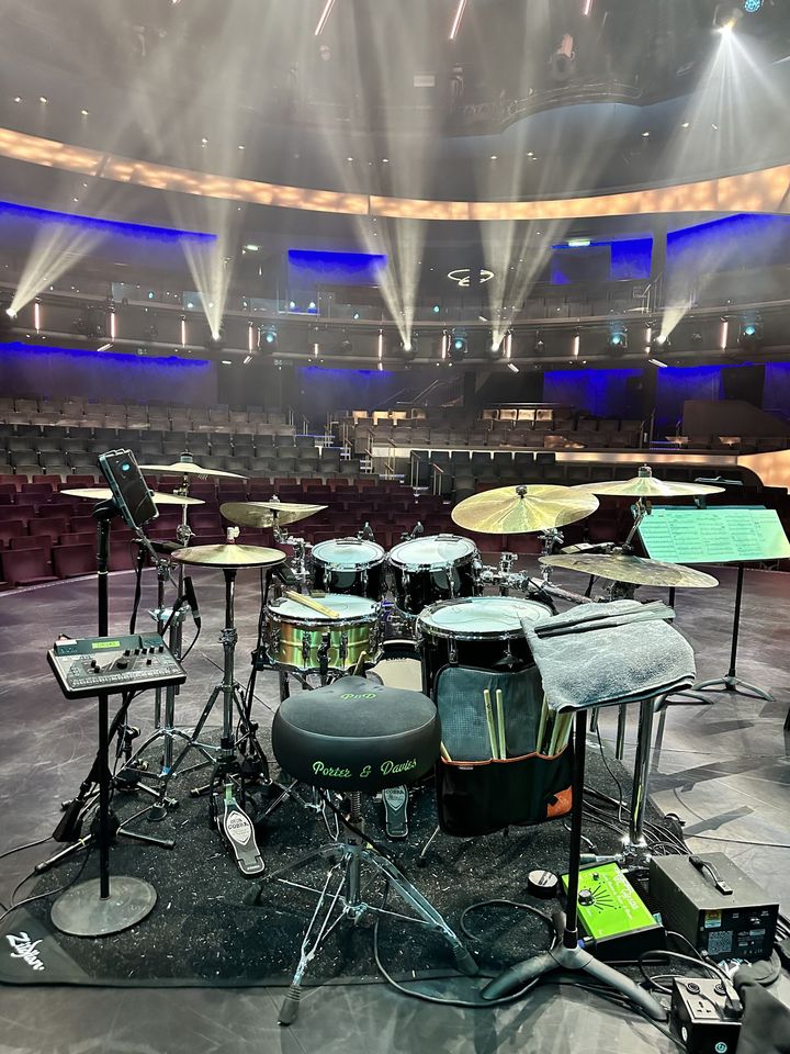 Kit set up on an arena stage under the lighting rig